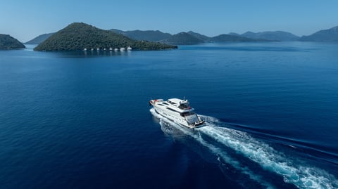 A premium white yacht cruising smoothly across deep blue waters, highlighting elegance and modern marine craftsmanship