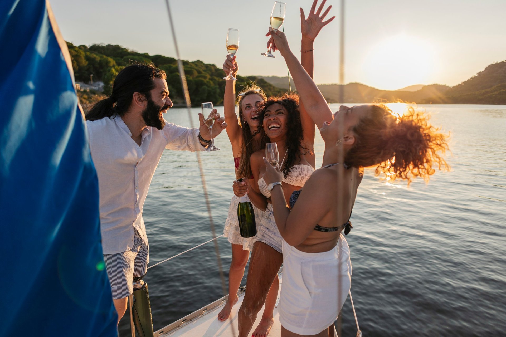 Friends celebrating with champagne on yacht at sunset