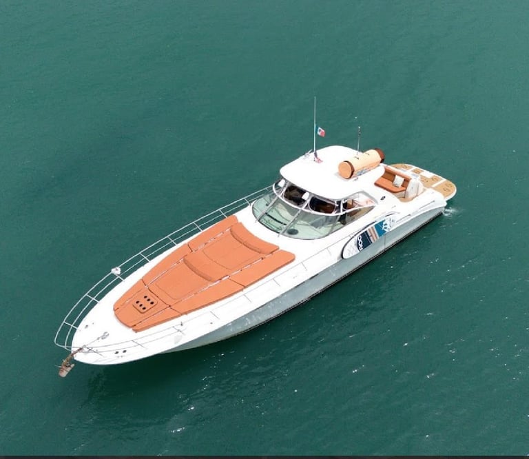 Aerial view of a white and orange luxury motor yacht floating on turquoise water