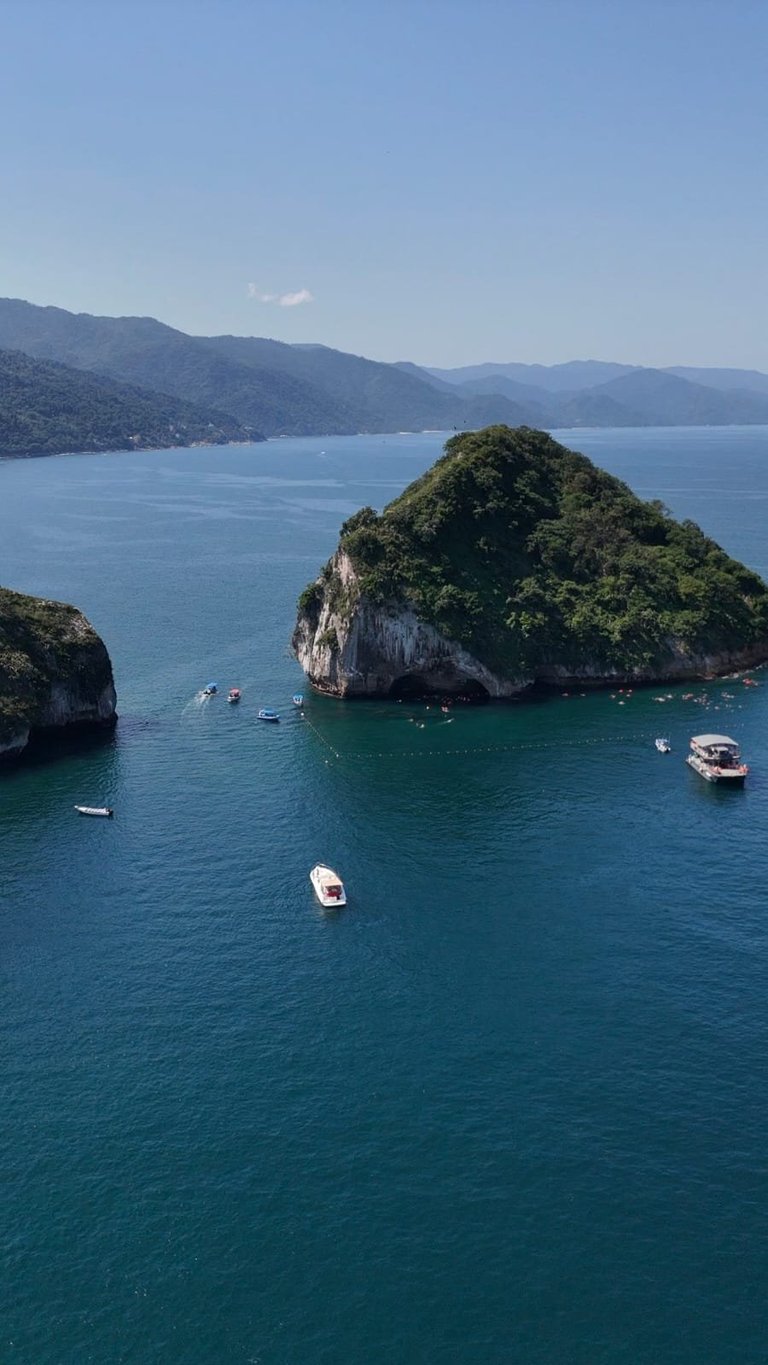 Aerial view of island with boats in turquoise water